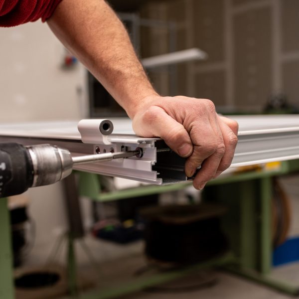 Male with a red shirt making a window with industrial tools A male with a red shirt making a window with industrial tools